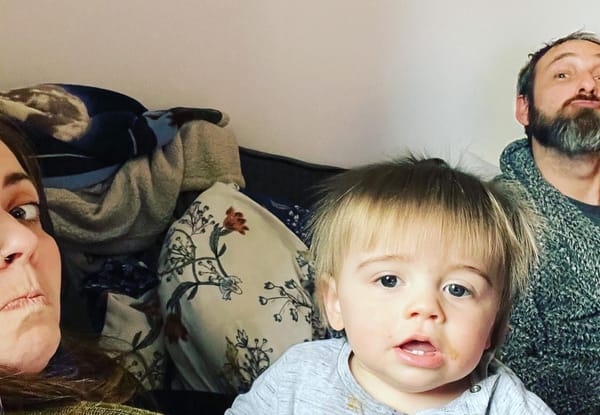 Allana, Mark and William smiling together in a cosy family photo